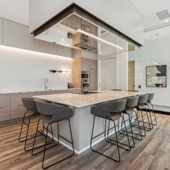 a modern kitchen with a large island and bar stools.