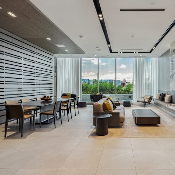 a modern living room with a dining area and a view of the outdoors.