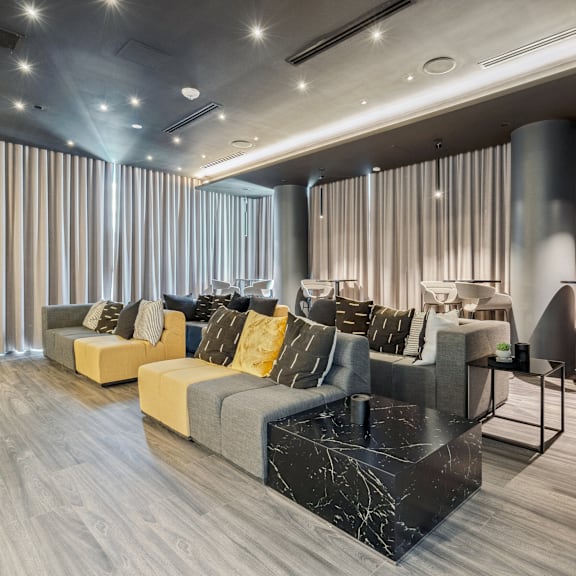 a modern living room with grey and yellow sofas and a marble coffee table.