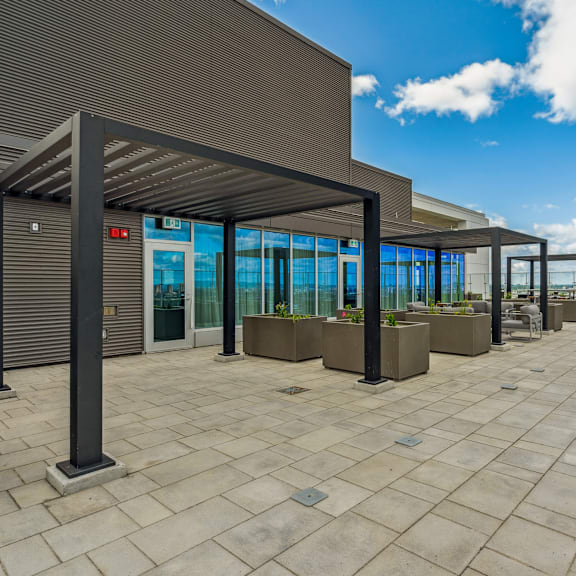a modern building with a glass facade and a covered walkway.
