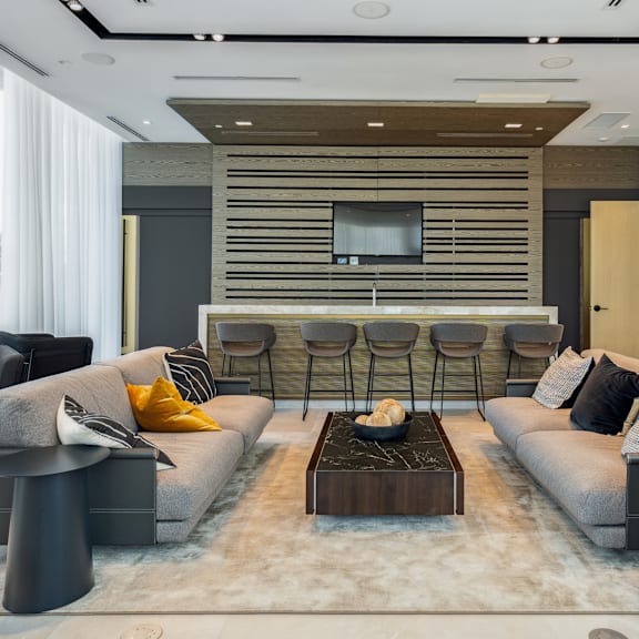 a modern living room with grey sofas and a wooden entertainment unit.