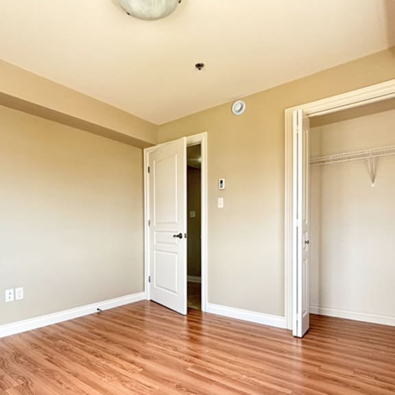 a room with a white door and a wooden floor.