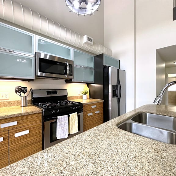 a kitchen with a granite countertop and stainless steel appliances.