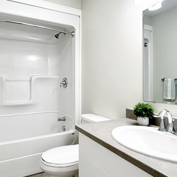 a white toilet sits in a white bathroom next to a white sink.