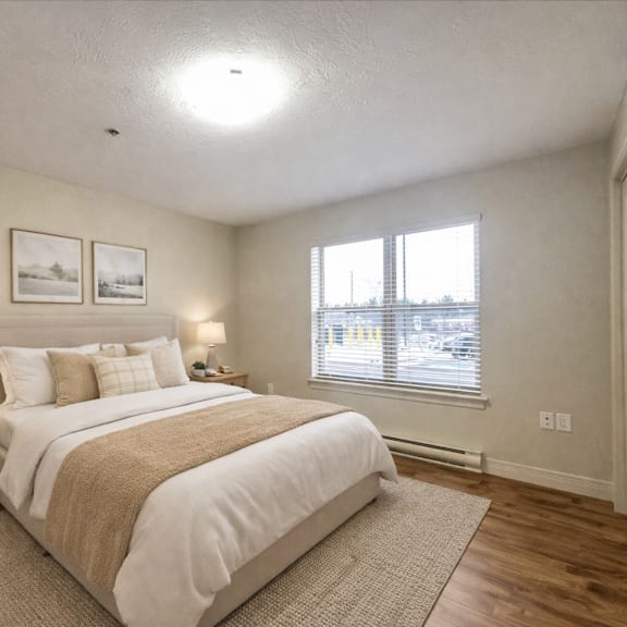 a bedroom with a large bed and two pictures on the wall.