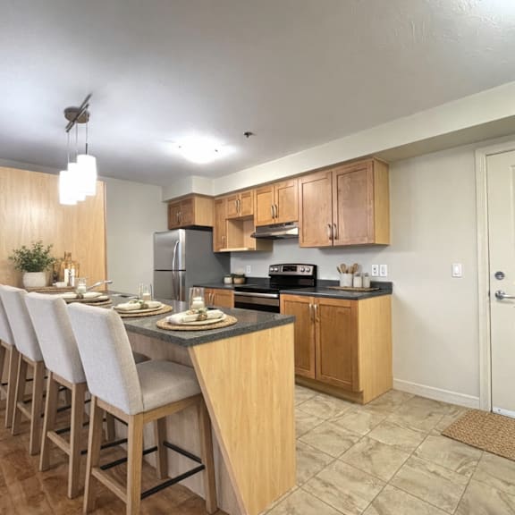 a kitchen with wooden cabinets and a black countertop.