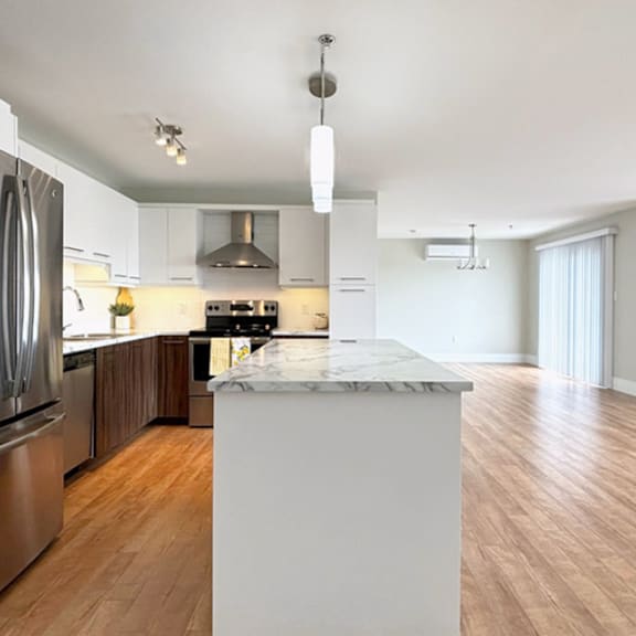 a modern kitchen with a marble island in the middle.