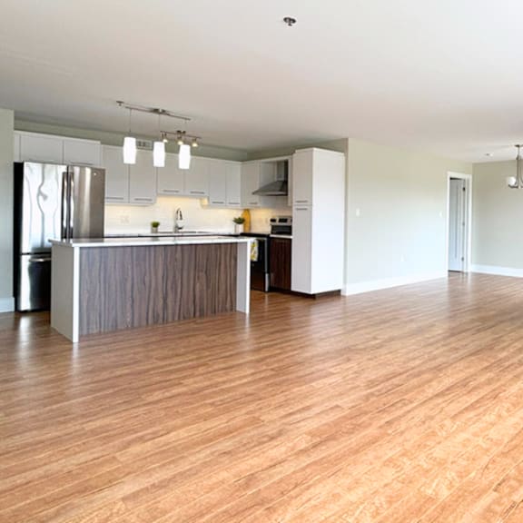 a kitchen with wooden floors and a refrigerator.