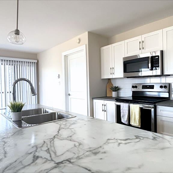 a kitchen with a marble countertop and stainless steel appliances.