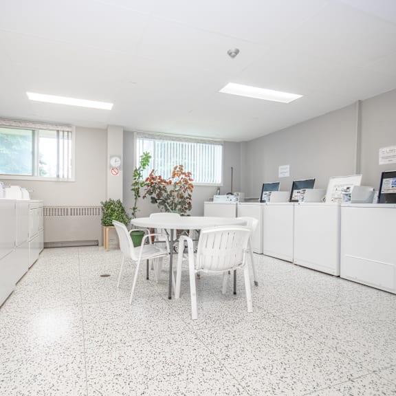 a white kitchen with a table and chairs.