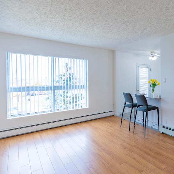 a room with a chair and a table with flowers on it.