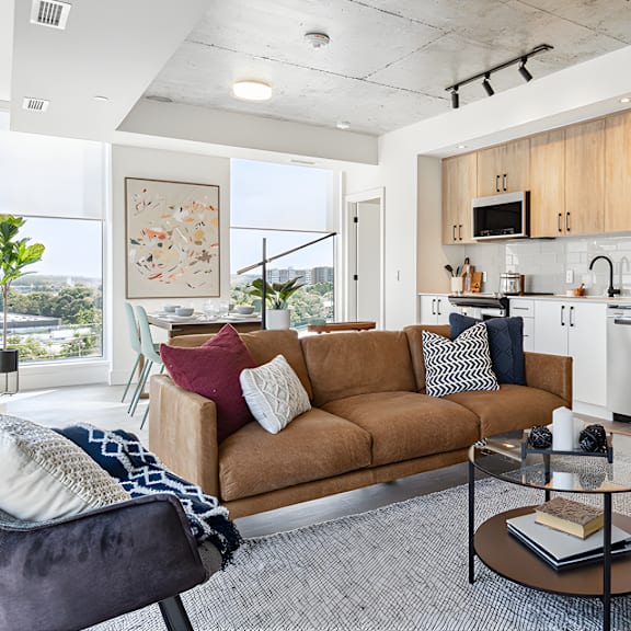 a modern living room with a brown sofa and a glass coffee table.