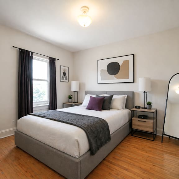 a bedroom with a large bed and a wooden floor.