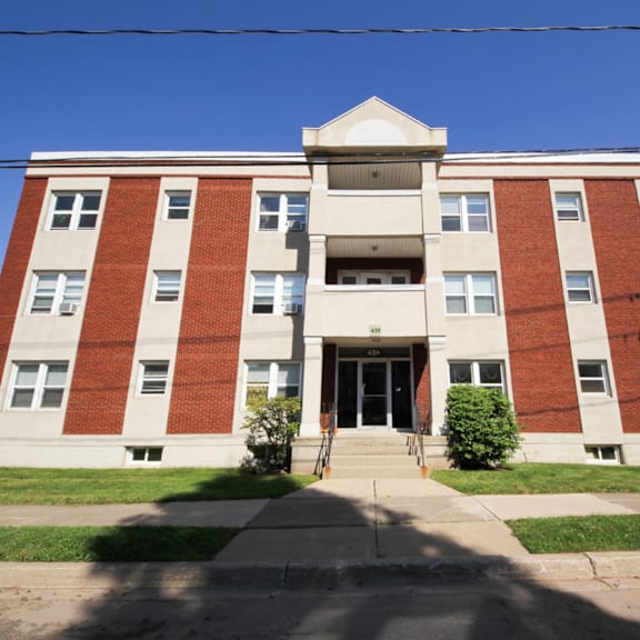 a red and white building with a black door and steps leading up to it.
