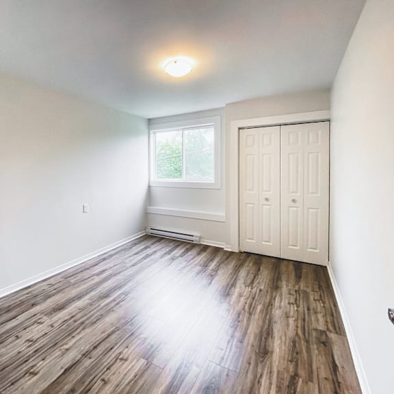 a room with wooden flooring and a white door.