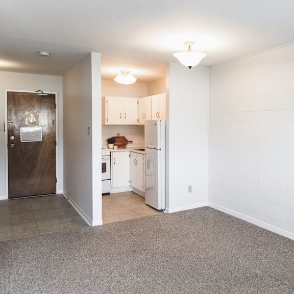 a kitchen with white cabinets and a brown door.