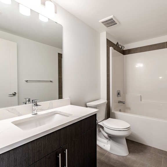 a modern bathroom with a white sink and toilet.