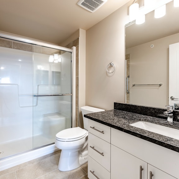 a bathroom with a toilet, sink, and shower.
