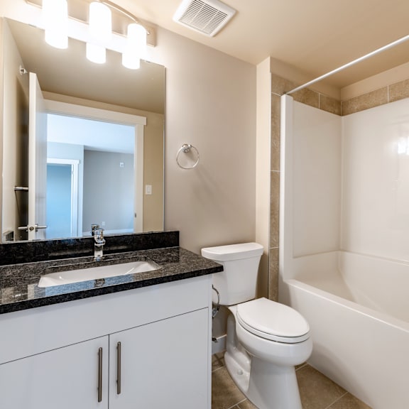a white toilet sits next to a white bathtub in a bathroom.