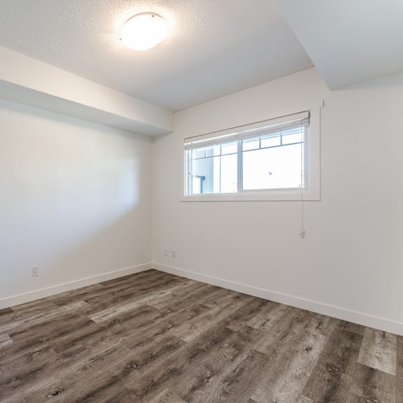 a room with a window and wooden flooring.