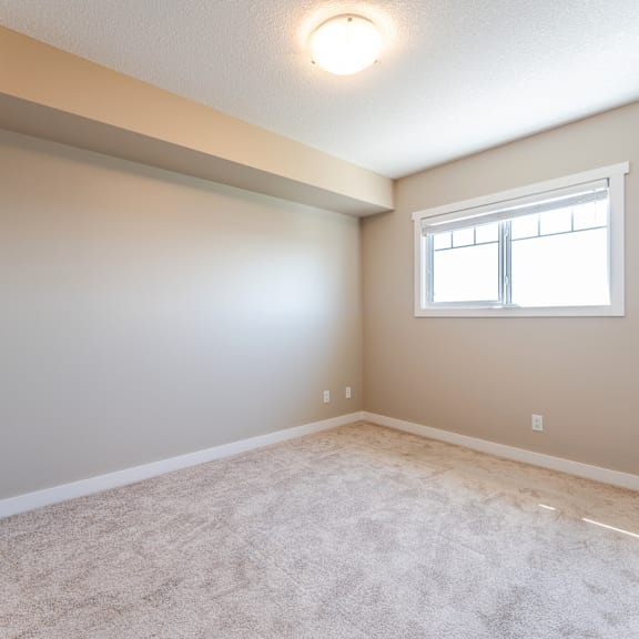 a room with a window and carpeted floor.