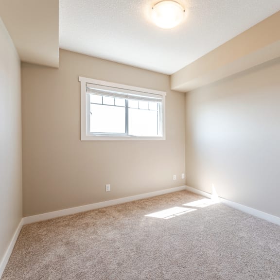a room with a window and carpeted floor.