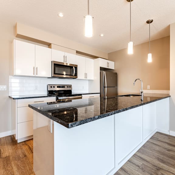 a kitchen with a black countertop and white cabinets.