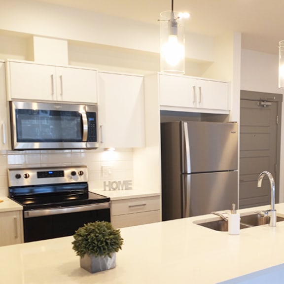 a modern kitchen with a stove, microwave, and refrigerator.