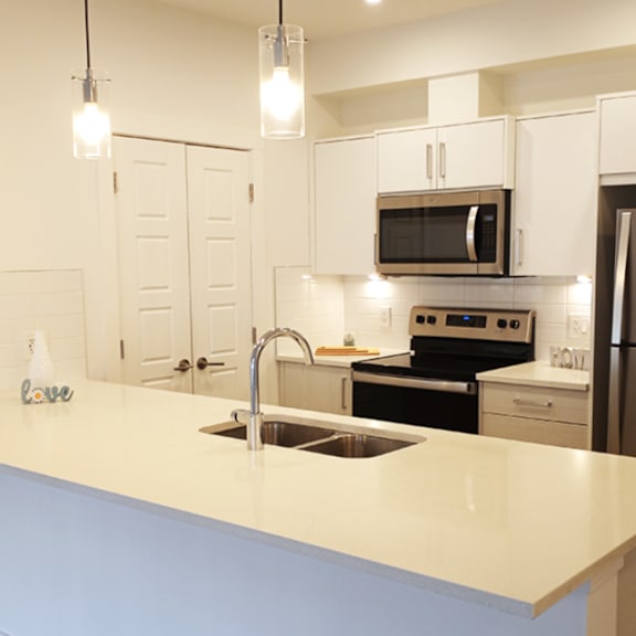 a kitchen with a sink, stove, and refrigerator.