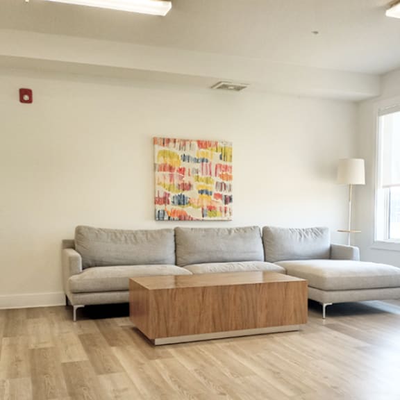 a living room with a grey couch and a wooden coffee table.