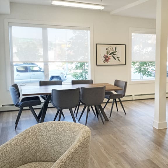 a room with a table and chairs and a painting on the wall.