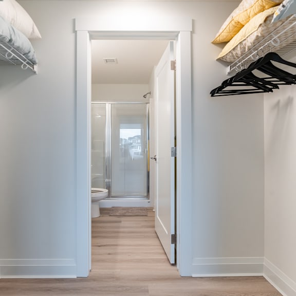 a hallway with a white door leading to a bathroom.