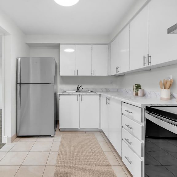 a modern kitchen with white cabinets and a stainless steel refrigerator.
