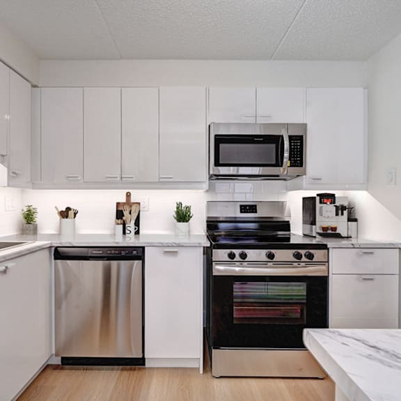 a modern kitchen with white cabinets and stainless steel appliances.