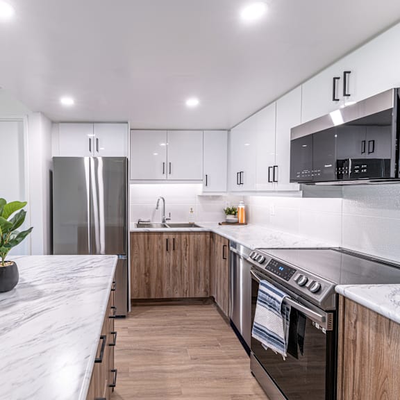 a modern kitchen with a marble countertop and stainless steel appliances.