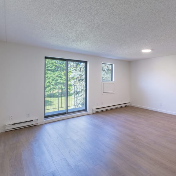 a room with a sliding glass door and wood flooring.