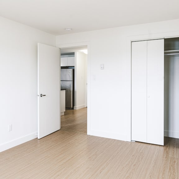 a white door is open in a room with wood flooring.