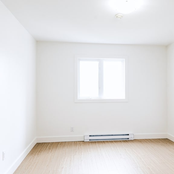 a room with a window and a radiator on the floor.