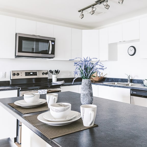 a kitchen with a black countertop and white cabinets.