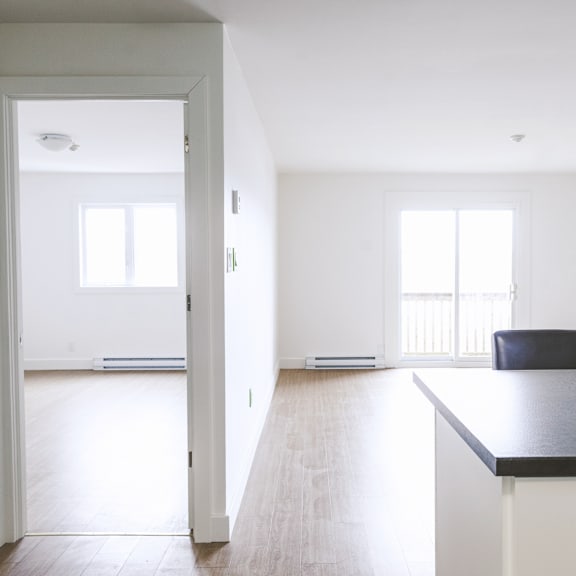 a black countertop with a white fridge and a black chair in the middle of the room.