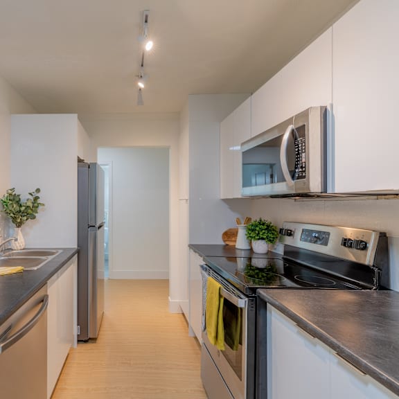 a modern kitchen with a stainless steel refrigerator, oven, and microwave.