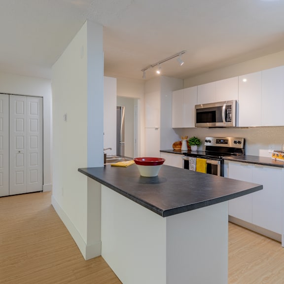 a kitchen with a black countertop and white cabinets.