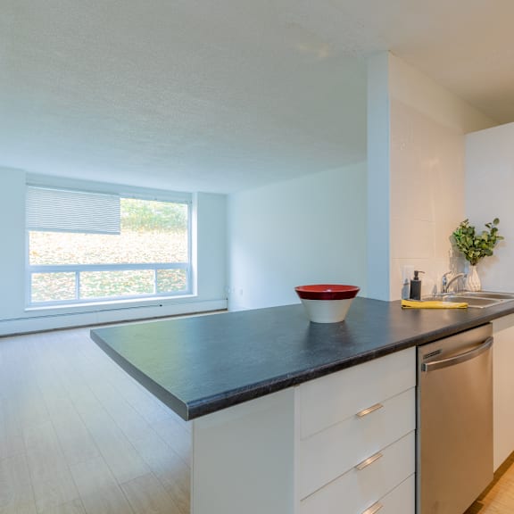 a kitchen with a black countertop and white cabinets.