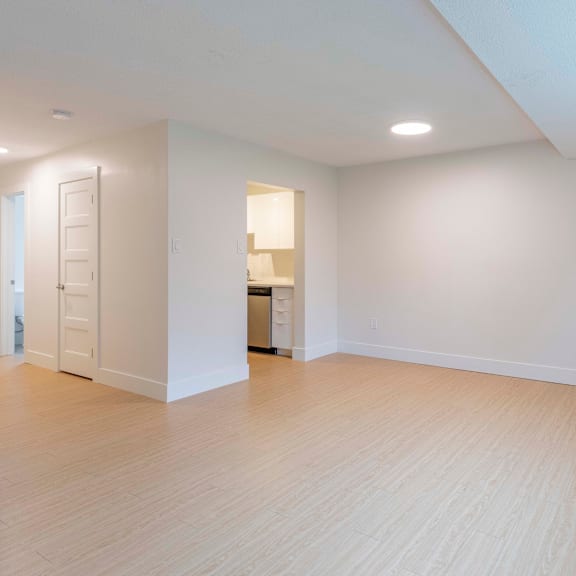 a large empty room with wooden floors and white walls.