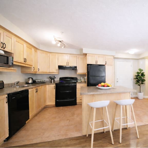 a kitchen with wooden cabinets and black appliances.