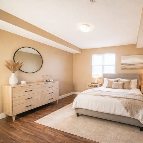 a bedroom with a large bed, a dresser, and a mirror on the wall.