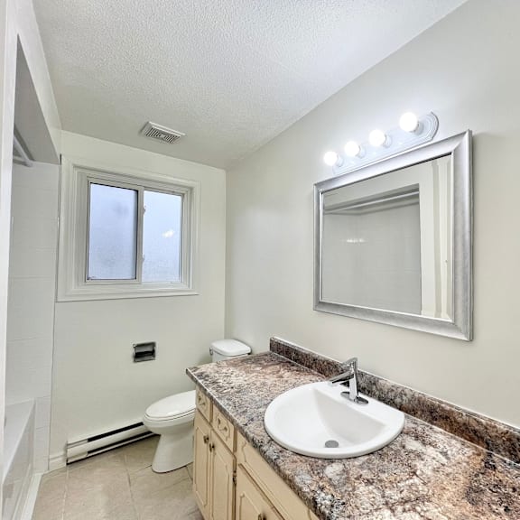 a bathroom with a granite countertop and a large mirror.