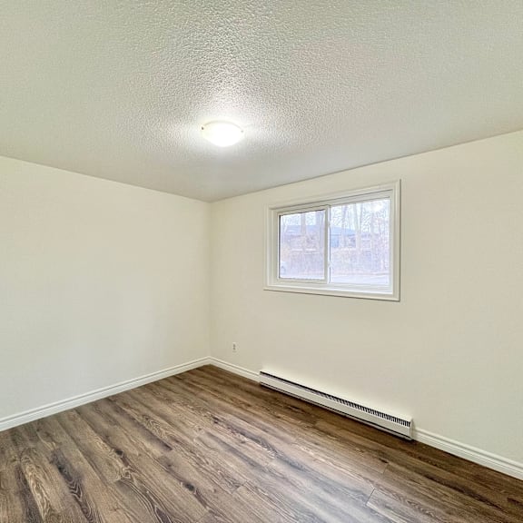 a room with a window and a radiator on the wall.