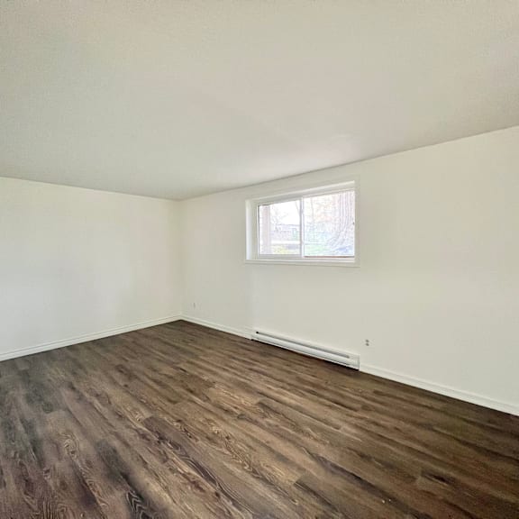 a room with wooden flooring and a window.
