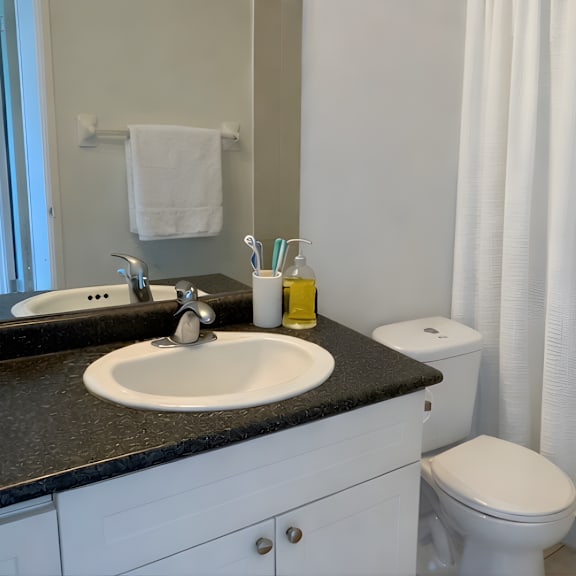 a bathroom with a sink, toilet, and shower curtain.